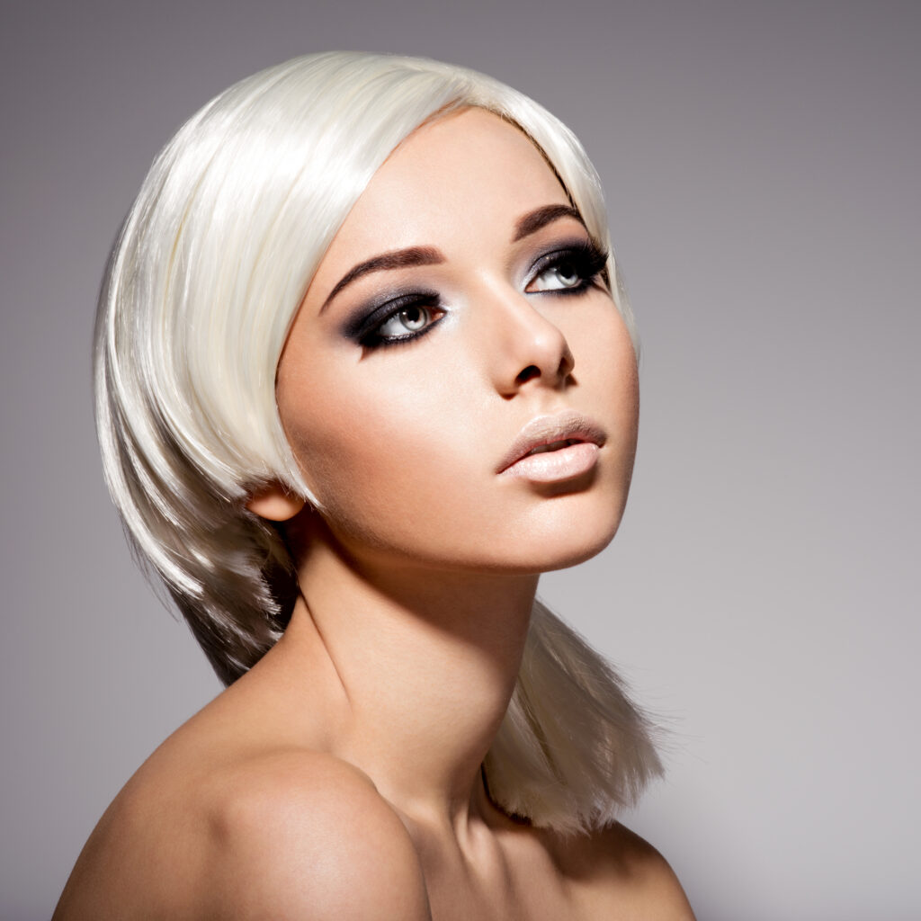 Fashion portrait of young beautiful woman with white hairs and black makeup of eye