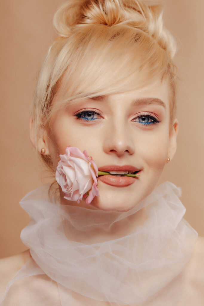 pretty attractive girl with blond hair, fashion shooting, rose, simple background, studio